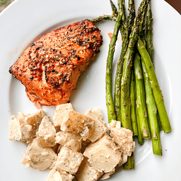 hot honey salmon on a plate with potato salad and asparagus
