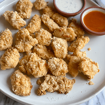buffalo chicken nuggets on a plate with ranch and buffalo sauce on the side