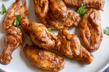Chili lime chicken wings on a plate with jalapeno ranch dipping sauce