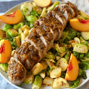 Peach glazed pork tenderloin on a bed of brussel sprouts, parsnips and white sweet potatoes- garnished with peaches