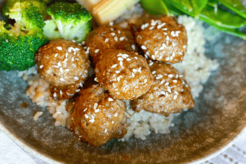 Orange Chicken Meatballs with broccoli, baby corn, snap peas and rice in a bowl