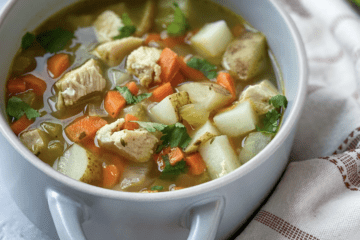 Chicken soup with carrots, celery, and potatoes in a bowl