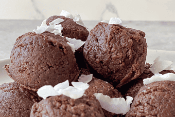 paleo chocolate date balls with coconut flakes on top