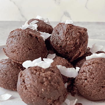 paleo chocolate date balls with coconut flakes on top