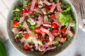 Pizza salad with tomatoes, salami, green peppers, mushrooms and olives
