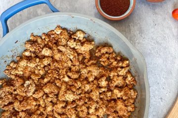 Quick and Easy Taco meat in a pan with seasonings, tomatoes and jalapeno surrounding it