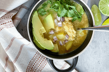 Instant Pot White Chicken Chili in a bowl topped with avocado slices and cilantro