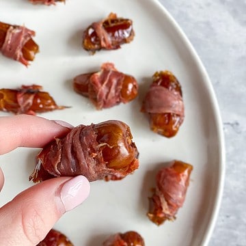Prosciutto wrapped date in hand