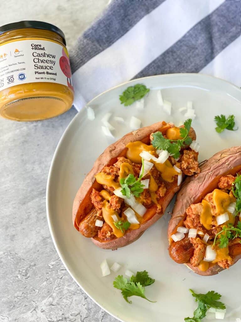 Paleo chili cheese dog in a sweet potato with onions and cilantro