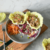 Pork Lettuce Wraps on a plate with cabbage and shredded carrots